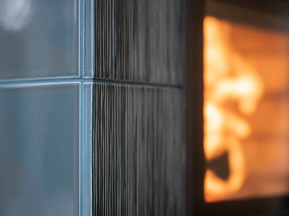 Detailed view tiled stove with fire tile MAXIMUS flute fine in turmalin dark glossy | © Hoxter GmbH
