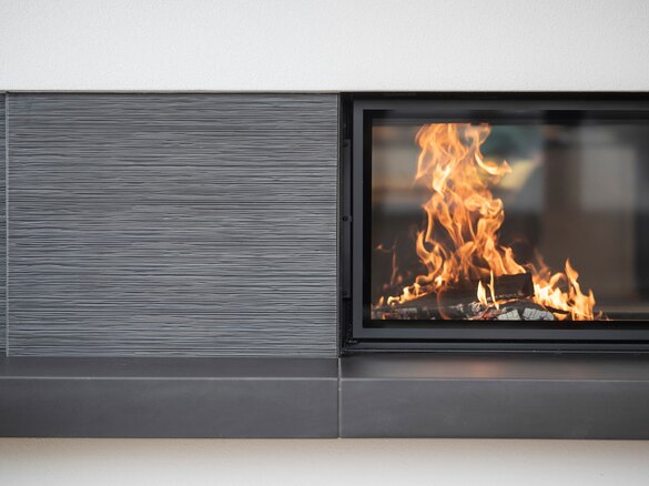 Detailed view tiled fireplace with fire tile MAXIMUS flute fine in lava | © Hoxter